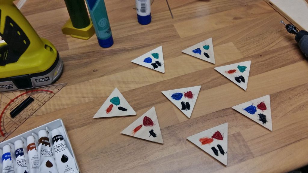 Triangles cut, symbols engraved and painted.
