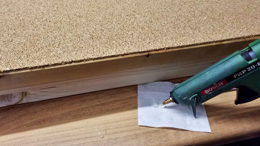 The cork mat's edges get an edge protector made from hot glue.