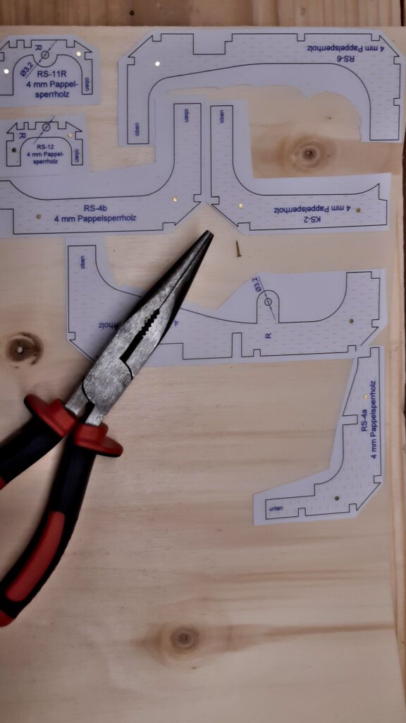 Die Bauteile werden ausgesägt. Nägel halten die doppelte Sperrholzplatte in Position.