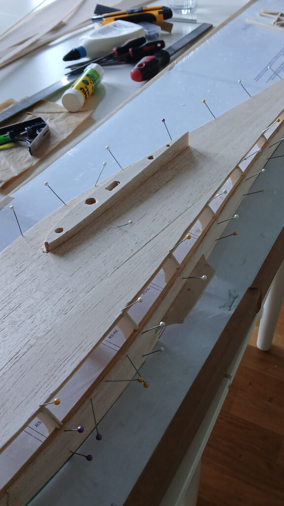 The planking made from balsa wood is being glued on.